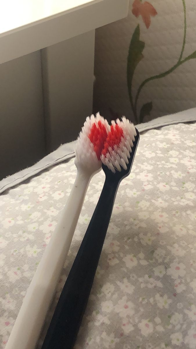 Two toothbrushes touching together